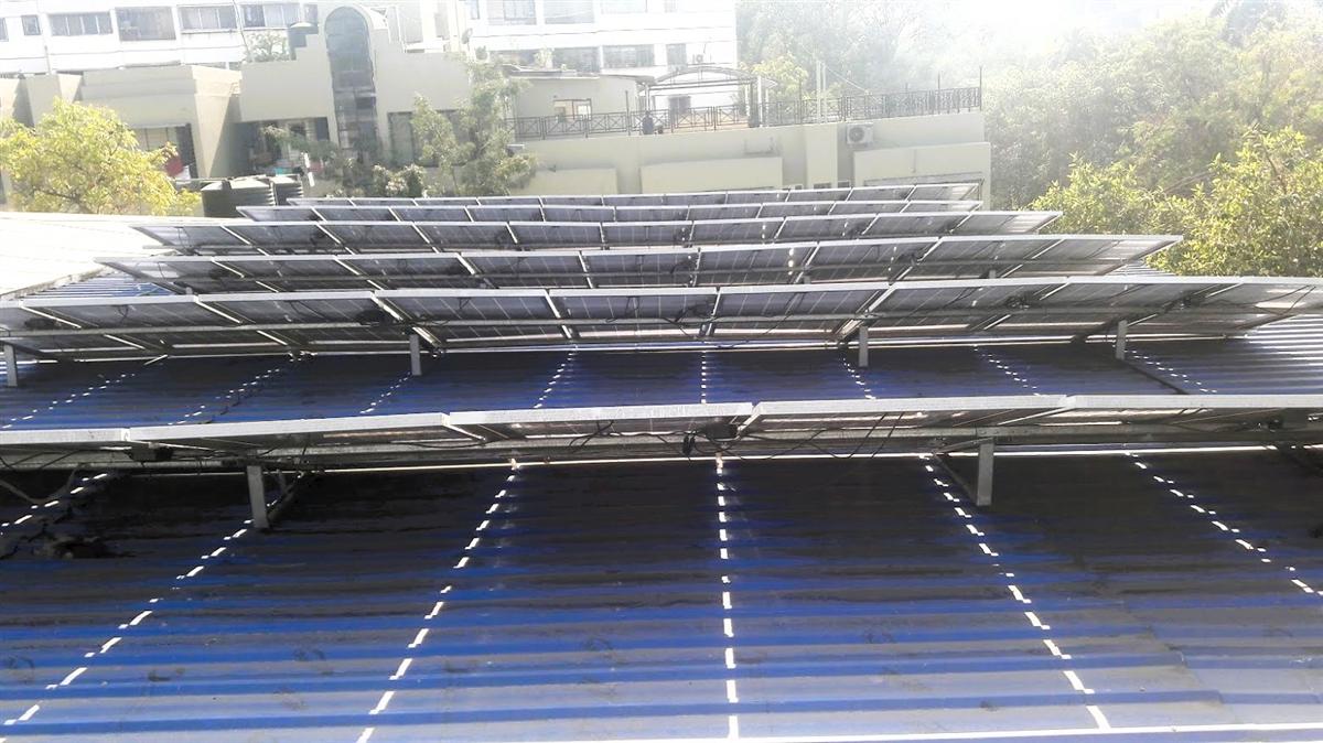 A custom-fabricated structure for solar panels on a large industrial roof.